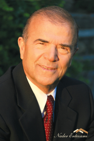 Realtor portrait in formal black suit with red tie and warm sunlight