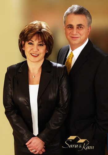 Realtor team portrait featuring two established professionals in formal attire with premium gold-toned logo